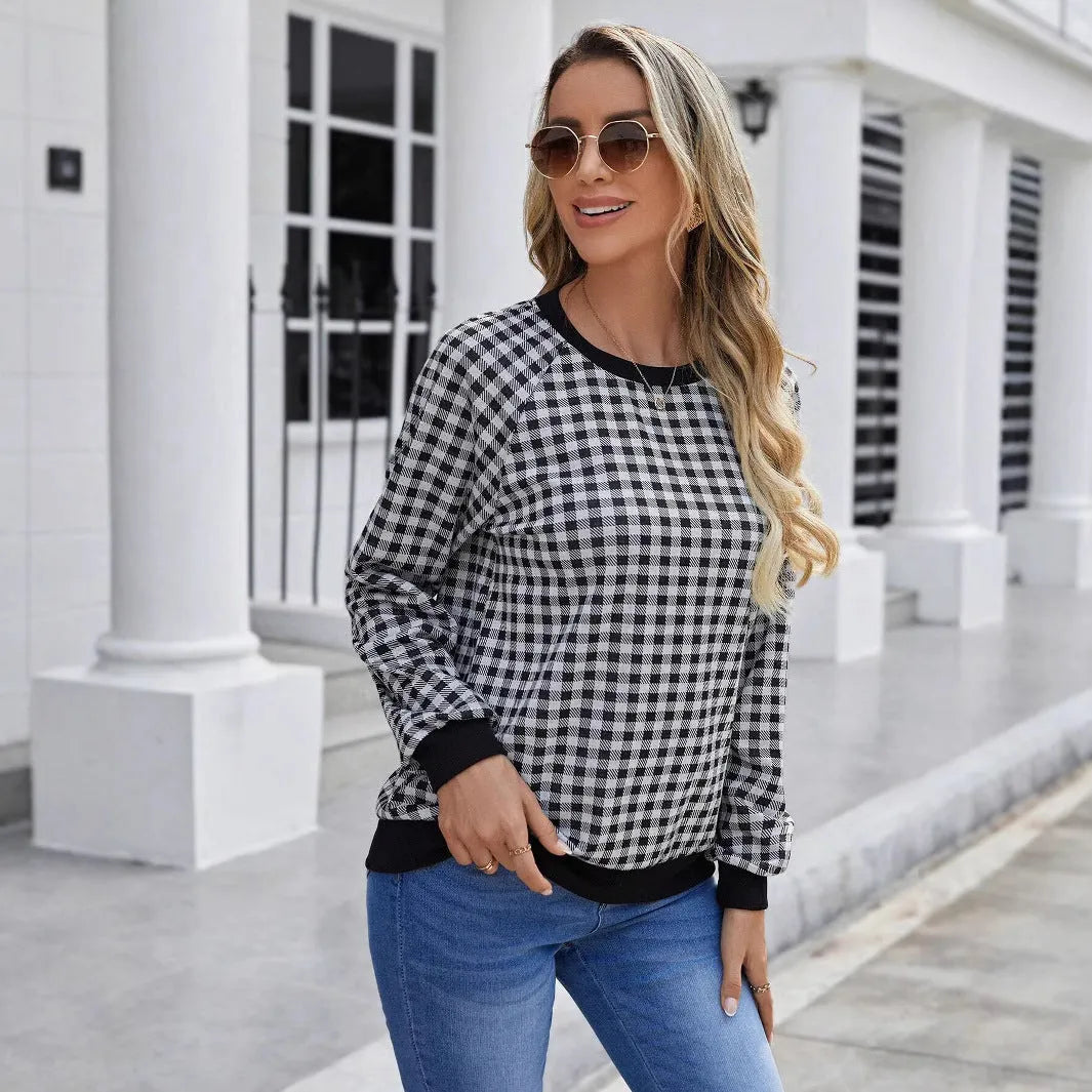 Black long sleeve pullover sweater with a striped plaid pattern and printed design detail.