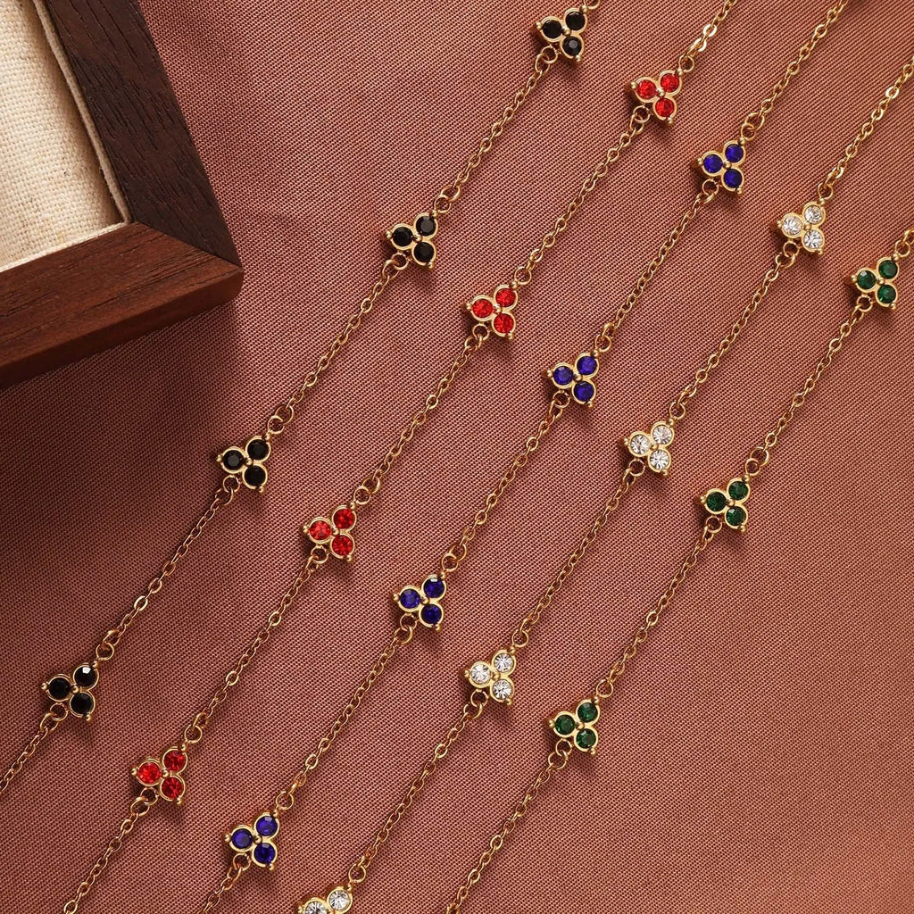 Women's stainless steel bracelet with a geometric triangle pendant, shown in gold and steel tone options with coloured stones.