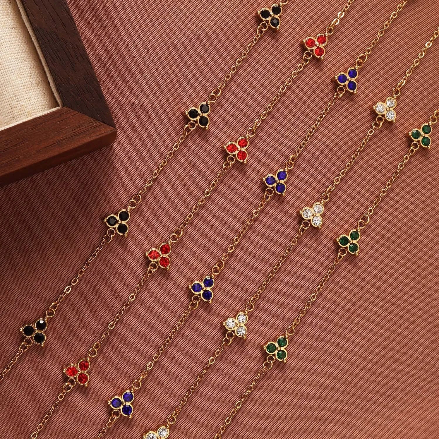 Women's stainless steel bracelet with a geometric triangle pendant, shown in gold and steel tone options with coloured stones.