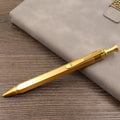 Brass bolt-action tactical pen in a retro copper finish, showing press mechanism and textured barrel.