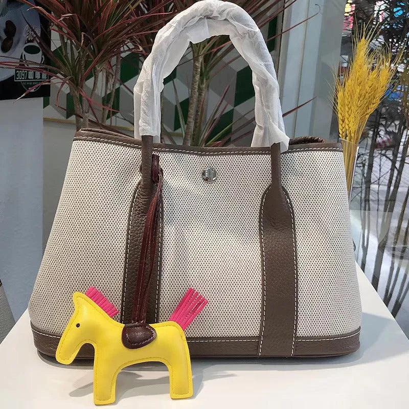 Women's canvas crossbody shoulder tote bag with leather detailing and bucket shape