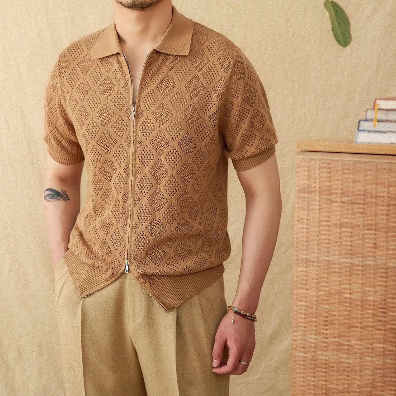 Light brown cotton short sleeve cardigan with lapel collar and front zipper closure on hanger