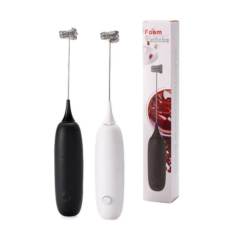 A hand-held electric milk frother in black and white colour options on a kitchen counter.