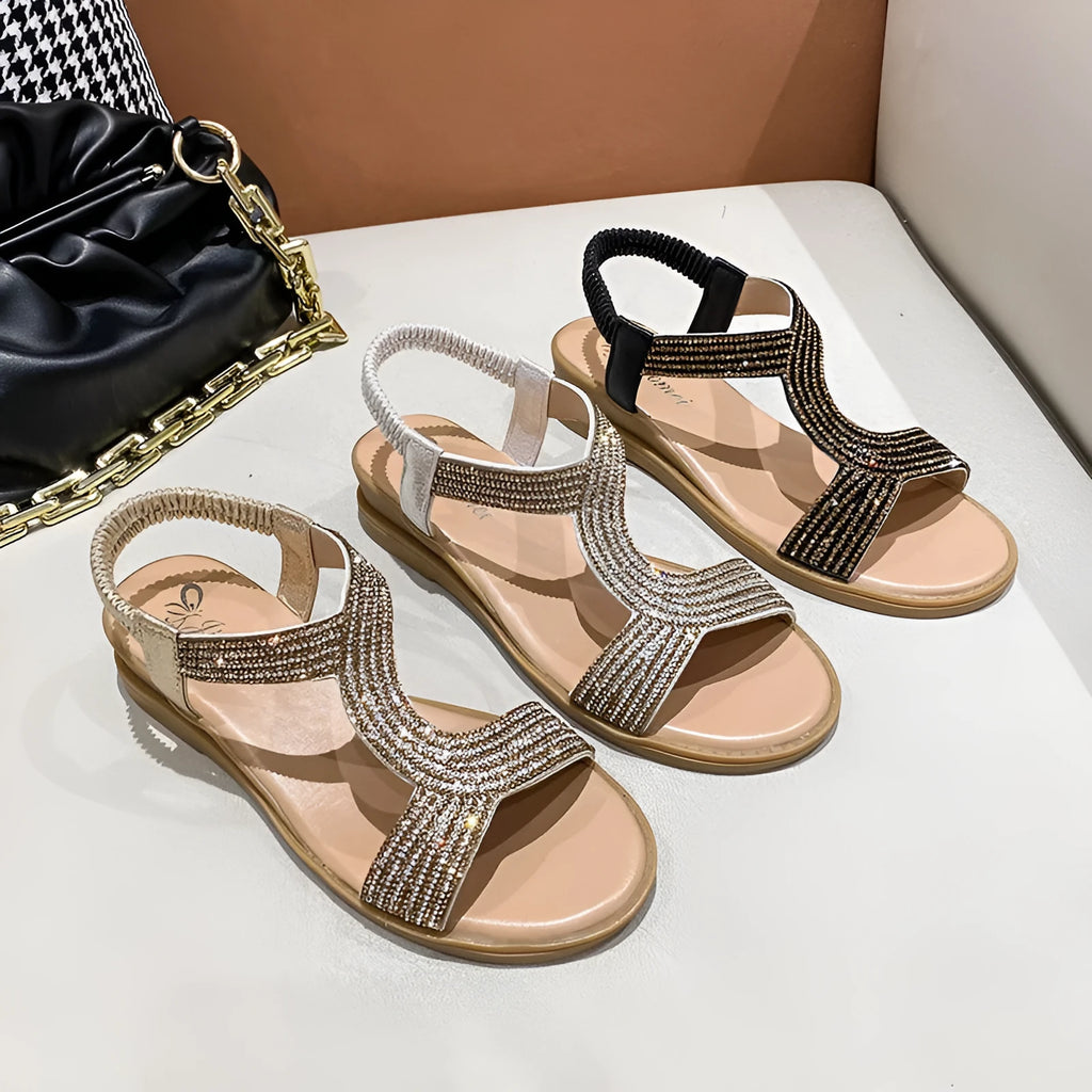 Women's patent leather sandals with rhinestone decoration on round toe shape, shown in gold colour