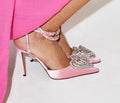 Women's pink satin sandals with pointed toe, heart-shaped rhinestones, and cross-belt ankle straps on a rubber sole.