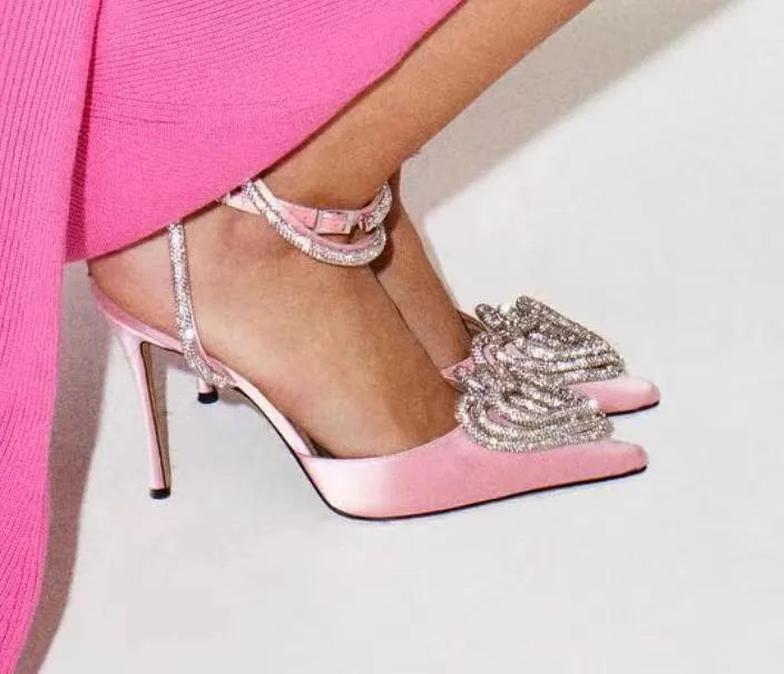 Women's pink satin sandals with pointed toe, heart-shaped rhinestones, and cross-belt ankle straps on a rubber sole.