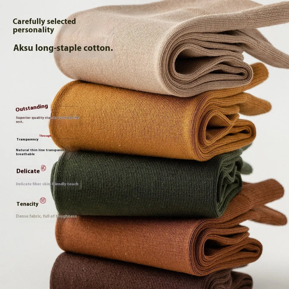 Men's solid colour mid-calf business socks made from combed cotton in various colours on a plain background.