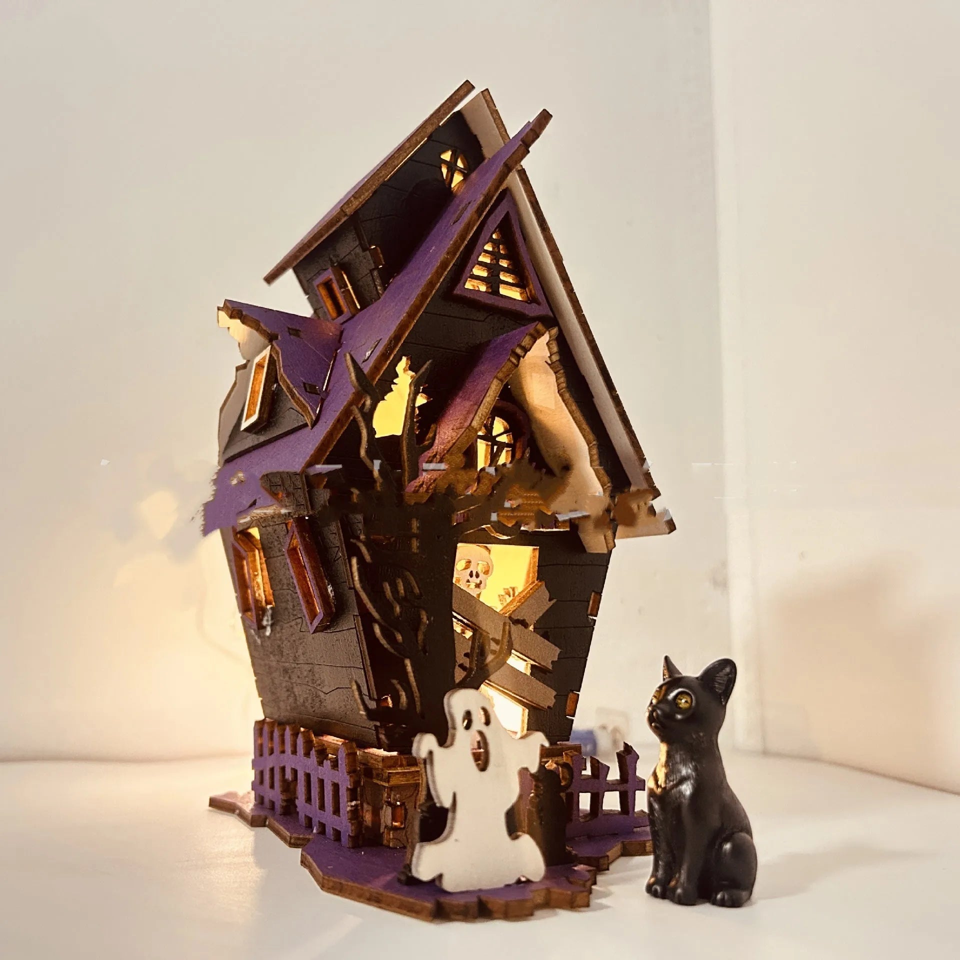 Wooden DIY Halloween haunted house table decoration with glow-in-the-dark details, shown unpainted.