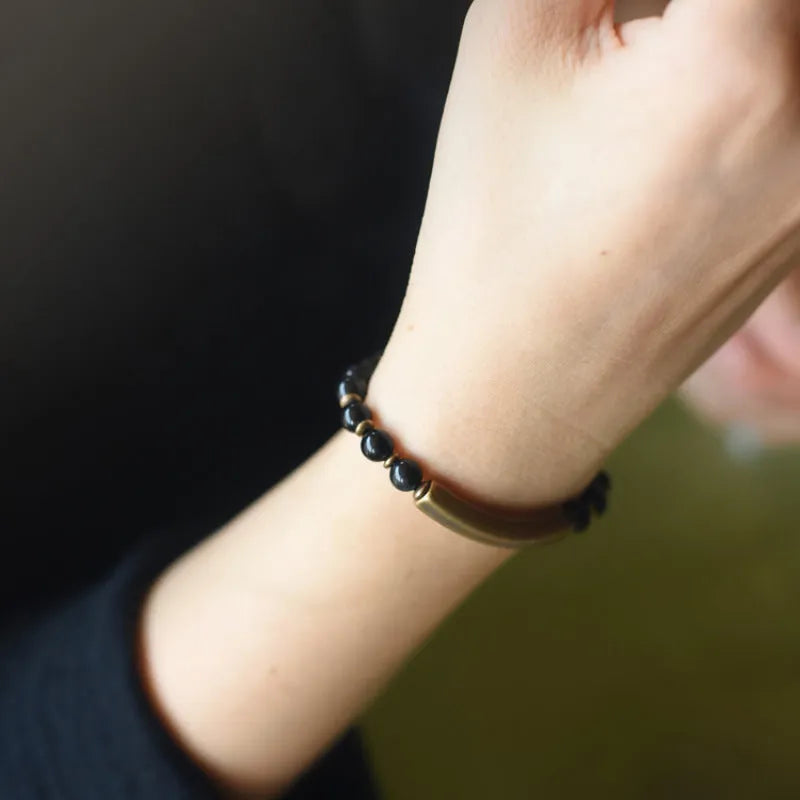 Layered ethnic bracelet with natural agate stones and brass charms on wrist
