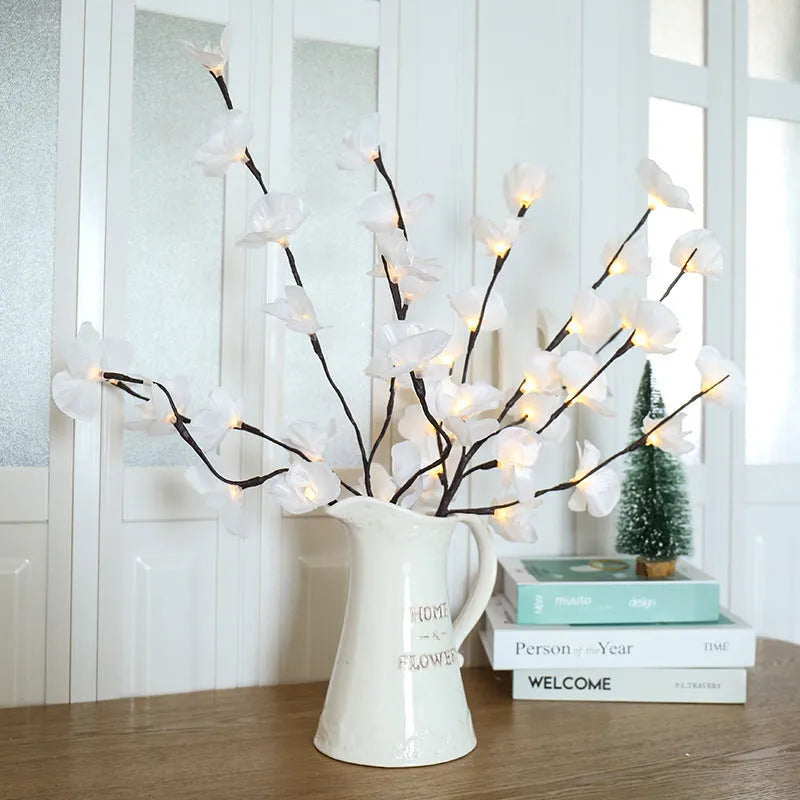 Pink Phalaenopsis orchid branch shaped LED decorative light on a table.