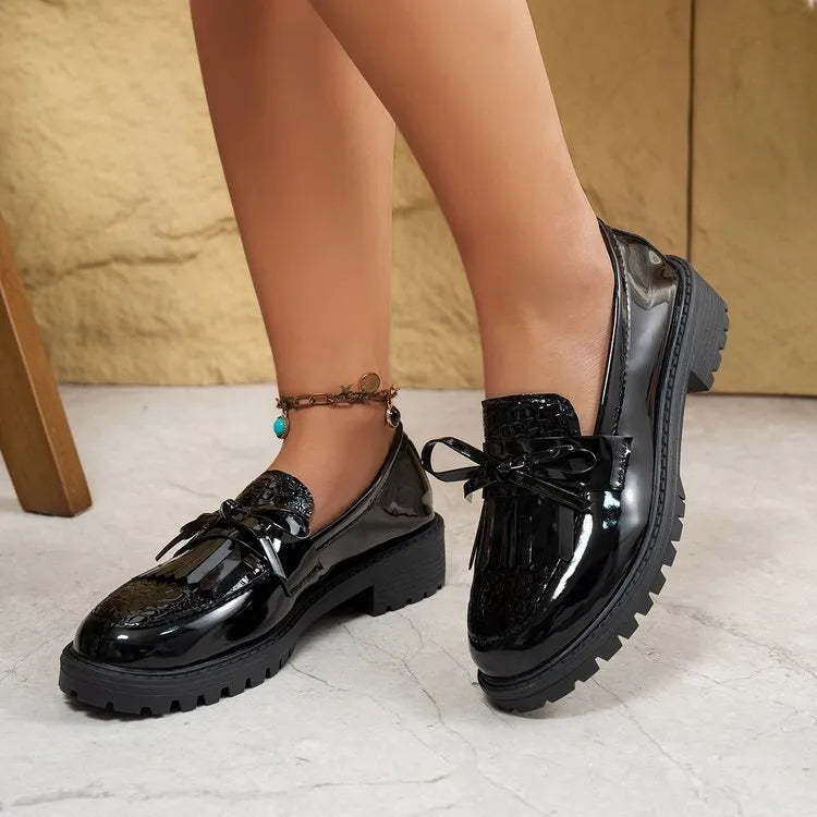 Women's black loafers with a bow detail on the front, made from artificial PU leather.