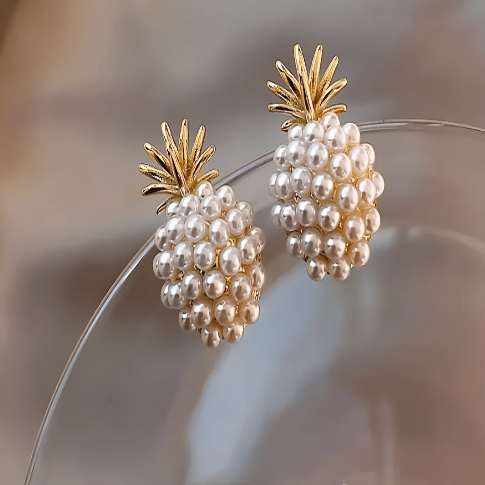 Gold Korean-style alloy earrings with pineapple starfish design and pearl-coloured gem inlays.