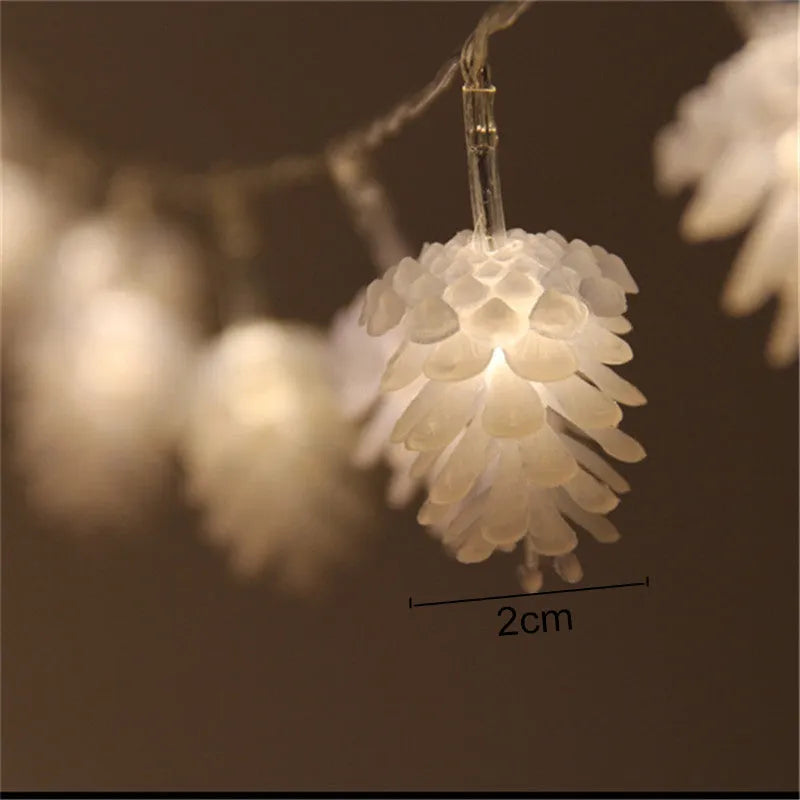 Warm white plastic pine cone LED light string powered by batteries on a dark background.