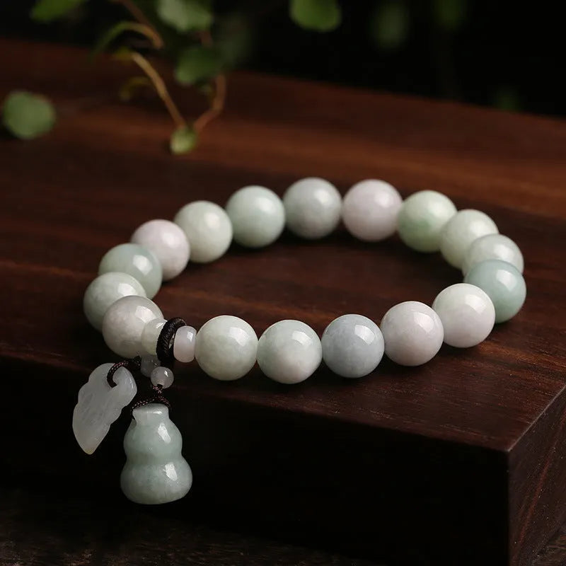 Emerald green jade bracelet with hanging symbolic charms including Maitreya Buddha design