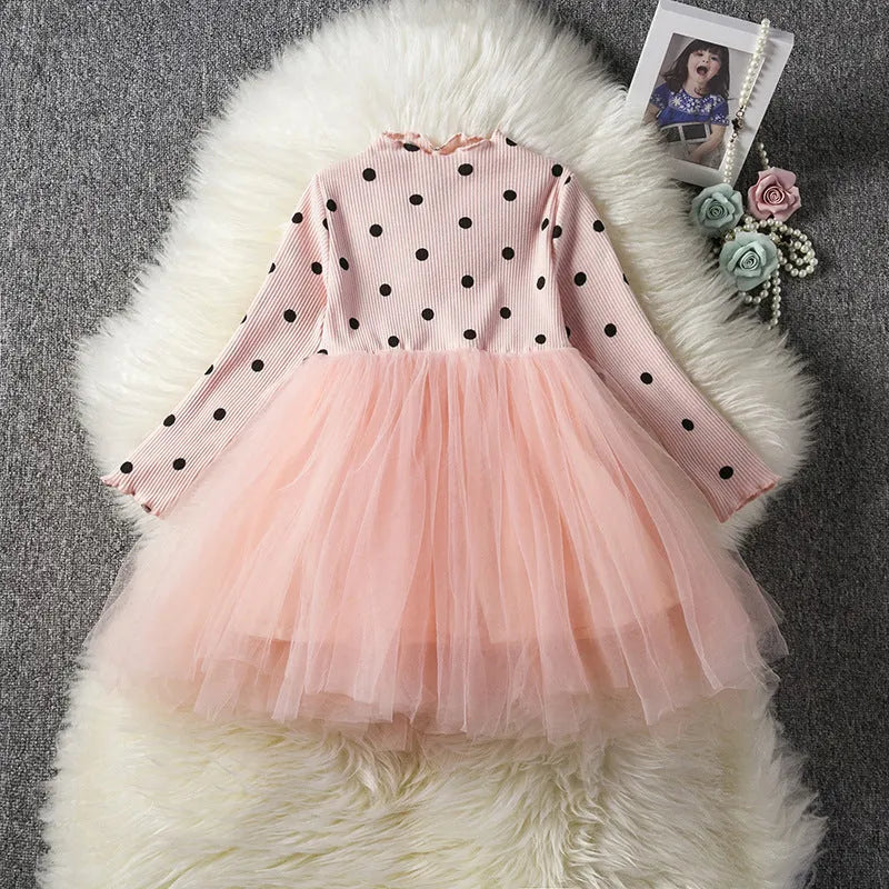 Baby girl wearing a long sleeve black lace tutu dress for a christening or birthday party.