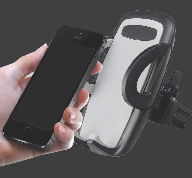 Black plastic car air vent phone holder mounted on car dashboard with mobile phone securely in cradle