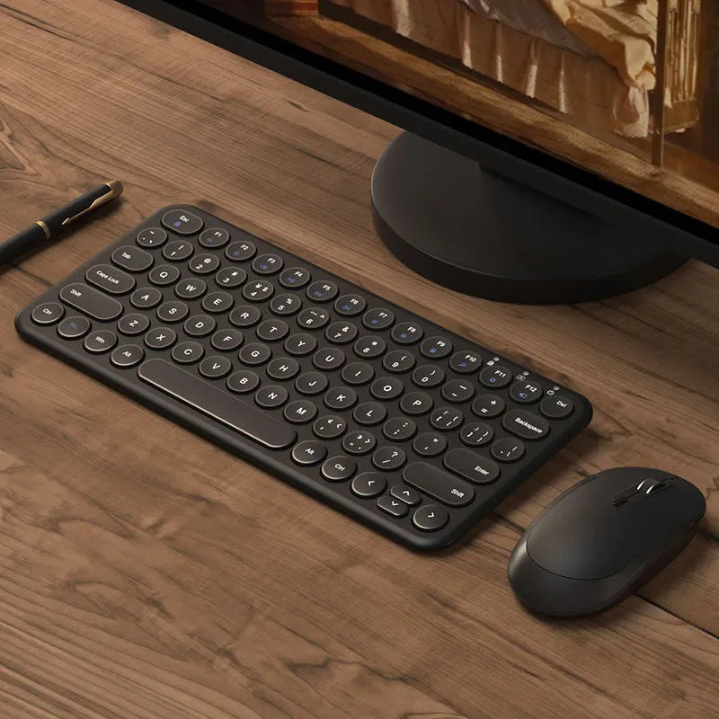 Ultra-thin white wireless keyboard and mouse set with USB receiver on a wooden desk.