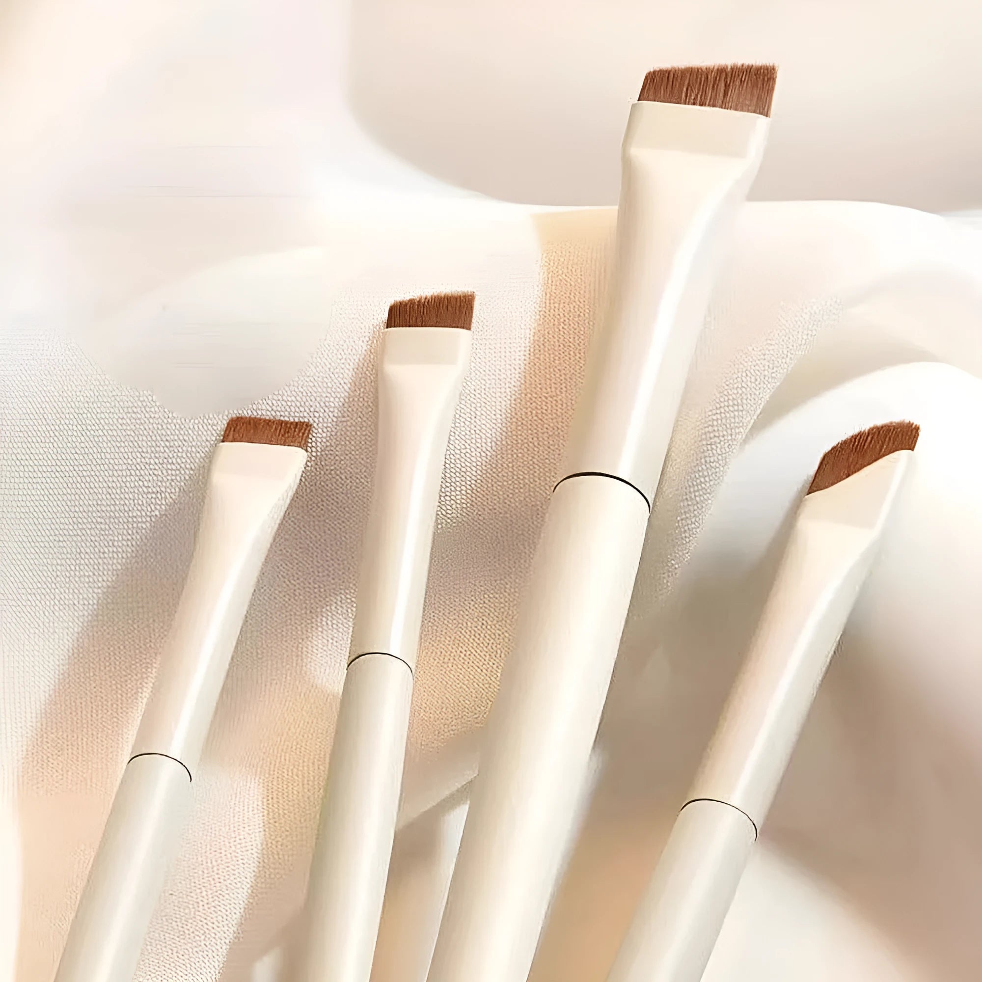 Four angled eyeliner and brow makeup brushes with ultra-thin tips in a leather case.