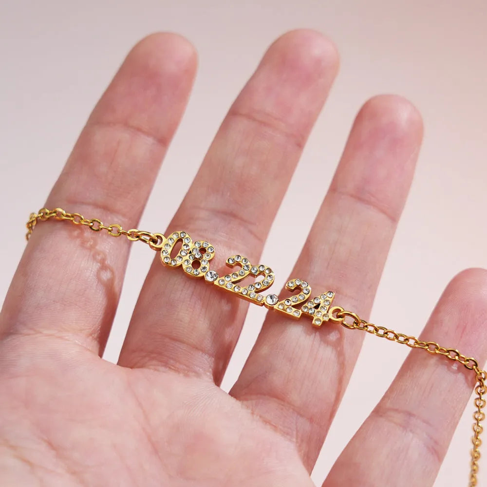 Stainless steel digital bracelet with diamond numerals on a metallic background.