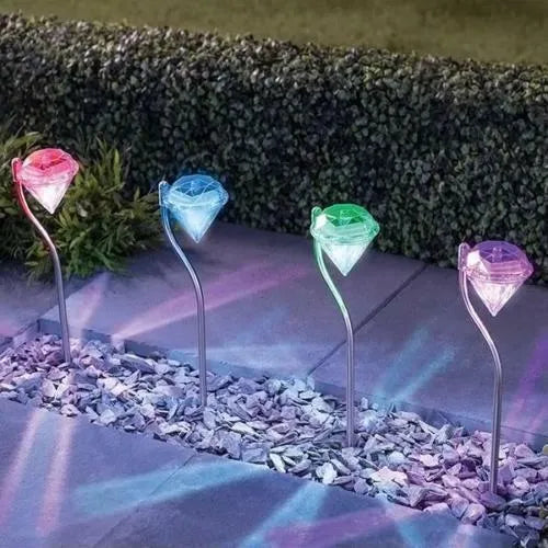 White solar-powered garden spotlight with adjustable head and solar panel on a stake for outdoor installation.