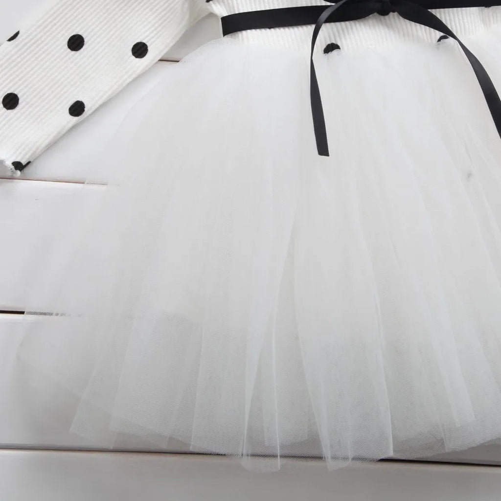 Baby girl wearing a long sleeve black lace tutu dress for a christening or birthday party.