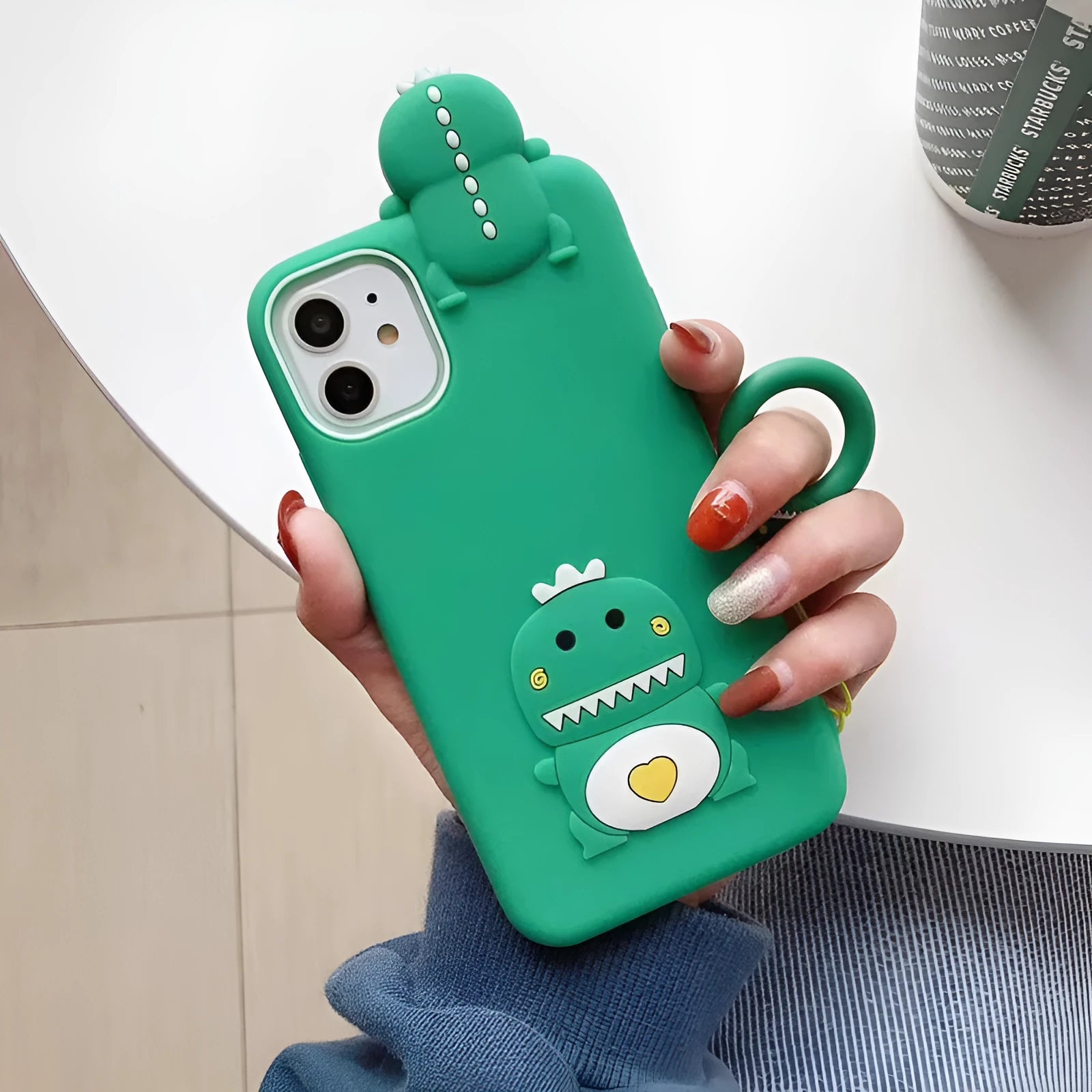 Green silicone phone case with a cartoon animal design for Apple iPhone models.