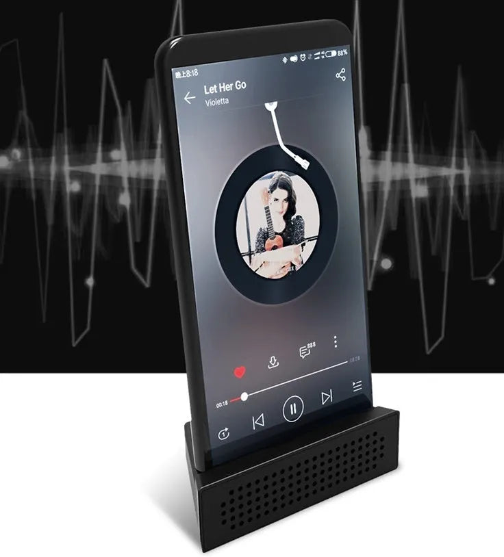 Compact black mobile phone amplifier bracket holding an iPhone on a desktop.