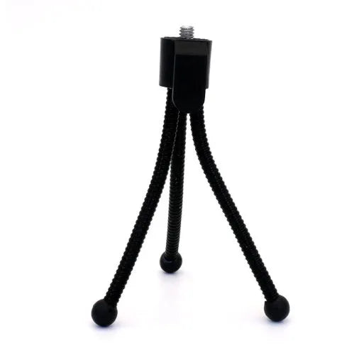 Small black iron mini tripod with ball head and folded legs on a table
