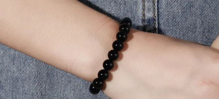 Geometric black onyx bracelet with 8mm beads on a black elastic cord.
