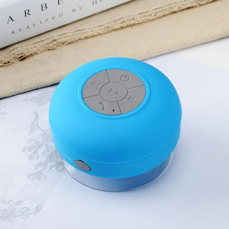 Portable Bluetooth speaker with suction cup showing front speaker grille and side buttons