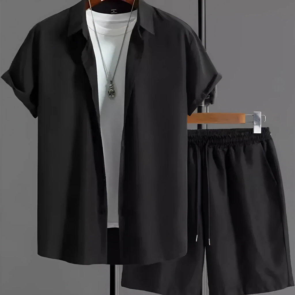 Man wearing a jacquard black short sleeve suit shirt with matching shorts from a two-piece set.