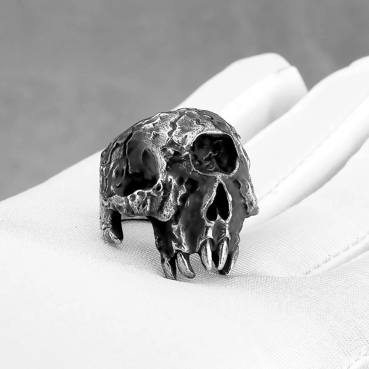 Alloy skull ring with one-eyed design in electroplated finish shown on finger