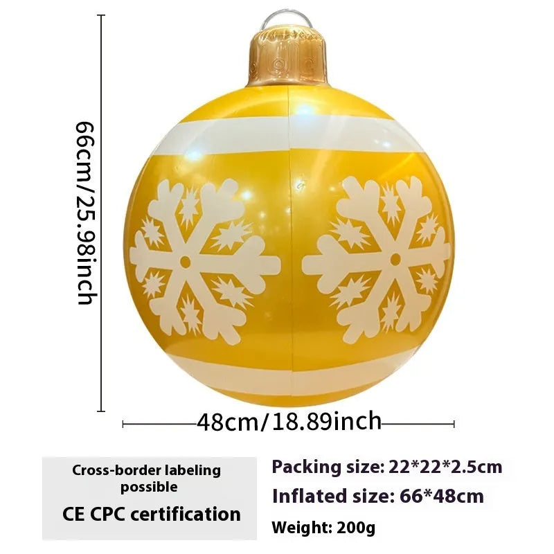 Large red inflatable Christmas ball with snowflake design and LED lights in outdoor garden setting