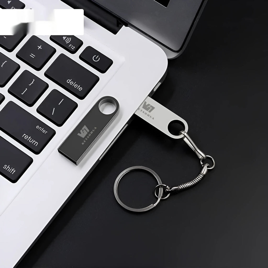 Silver metal car-shaped USB flash drive on a white background showing compact size.