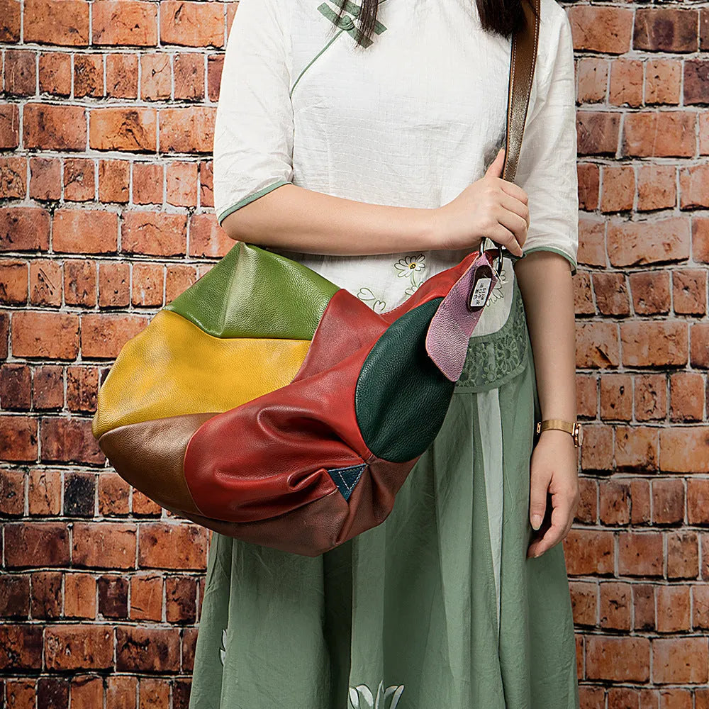 Cowhide leather crossbody travel bag showing stitching detail and capacity for 15-inch laptop