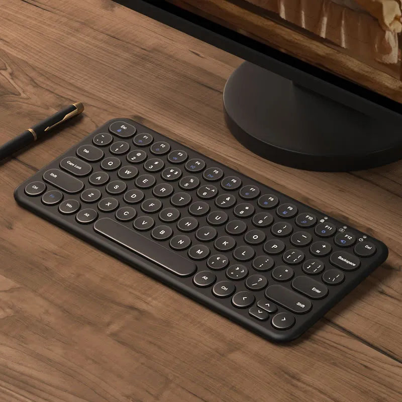 Ultra-thin white wireless keyboard and mouse set with USB receiver on a wooden desk.