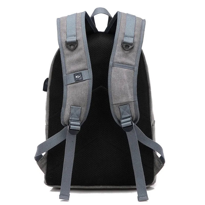 Canvas USB rechargeable backpack in grey showing front pocket and shoulder strap