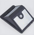 Four white solar LED security lights with motion sensors mounted on outdoor wall