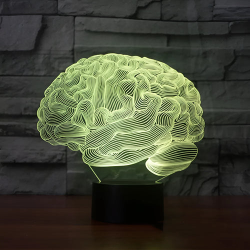 3D acrylic brain illusion LED desk lamp with remote control on a wooden table.