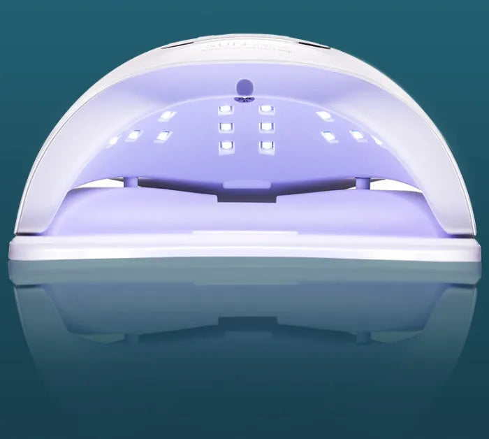 White nail polish dryer lamp with UV and LED light beads and digital timer display.