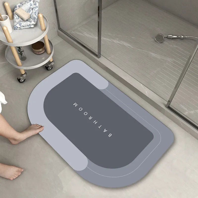 Blended fabric bathroom floor mat in blue colour, shown in an oval shape on a tiled floor.