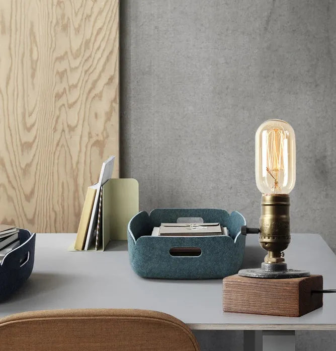 Industrial-style wooden and iron water pipe table lamp on a surface, showing its compact size.