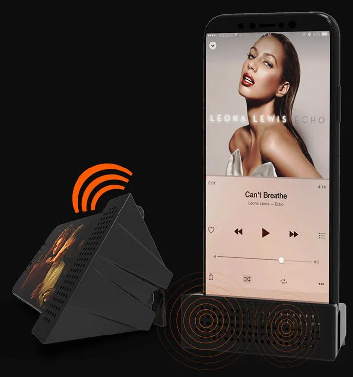 Compact black mobile phone amplifier bracket holding an iPhone on a desktop.