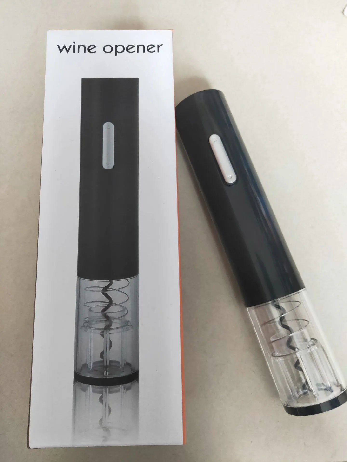 Automatic electric wine bottle opener with foil cutter in black, showing compact design and button operation