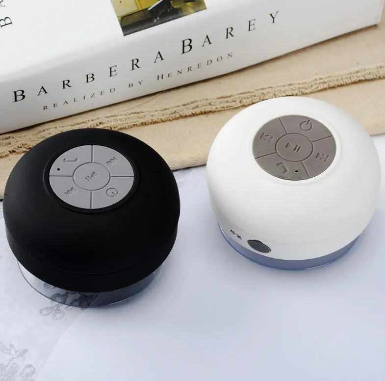 Portable Bluetooth speaker with suction cup showing front speaker grille and side buttons