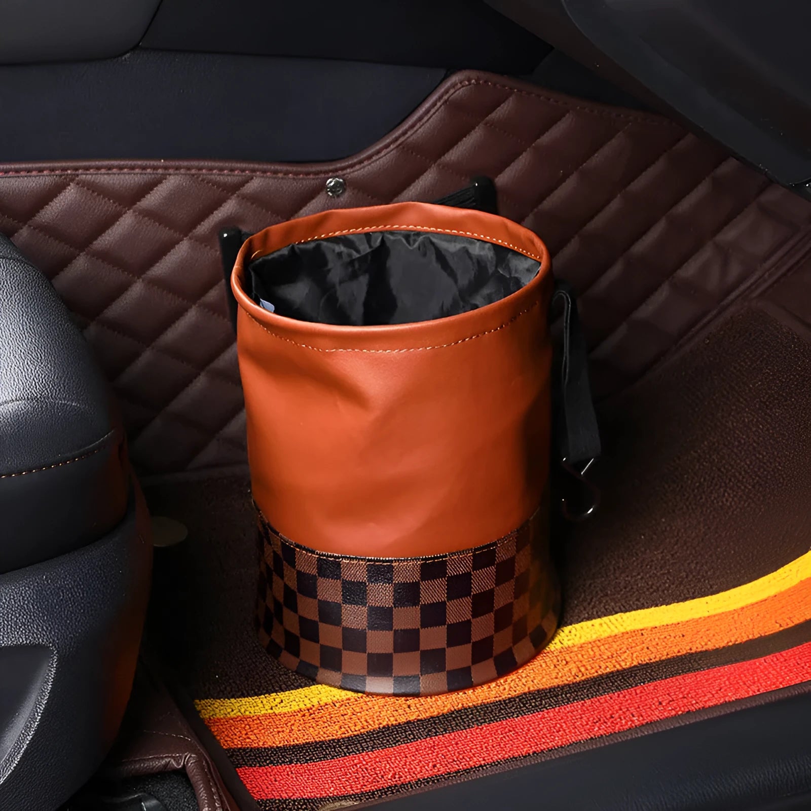 Black leather retractable foldable car trash can with handle shown open and folded.