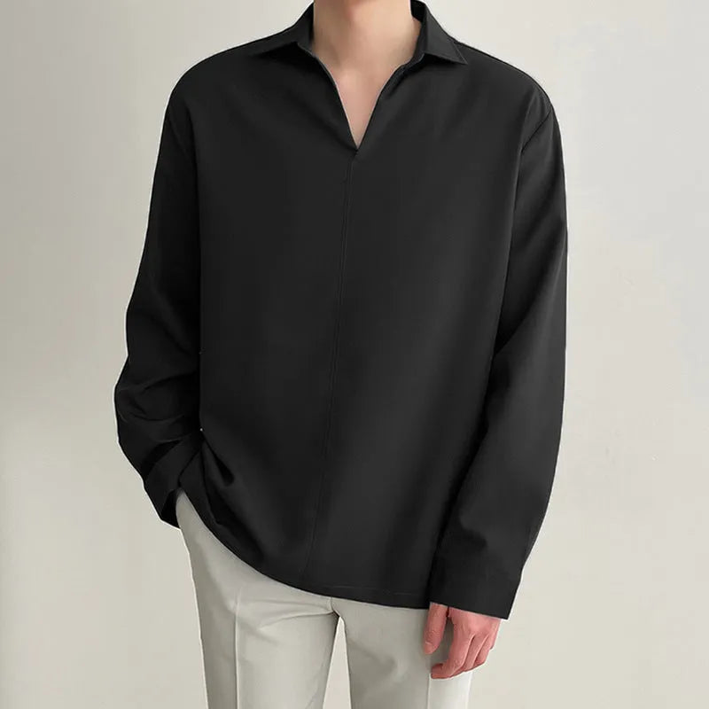Man wearing a loose fit light business casual shirt in blue, showing lapels and long sleeves.