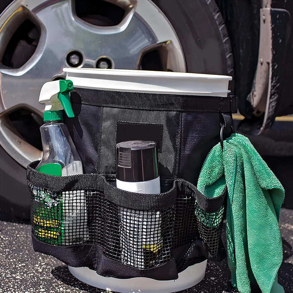 Black cylindrical polyester storage bag hanging on a 5-gallon barrel for outdoor tool organisation