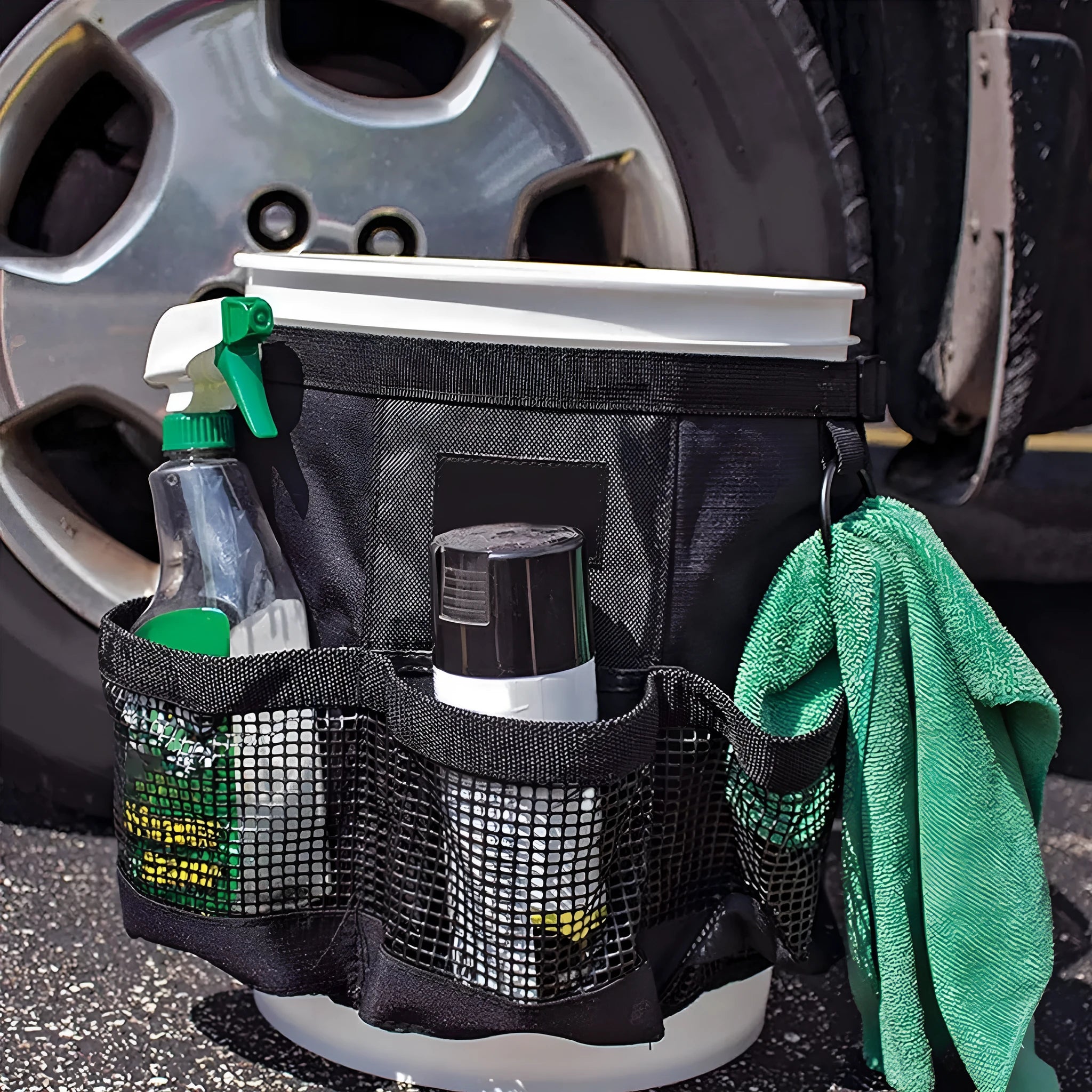 Black cylindrical polyester storage bag hanging on a 5-gallon barrel for outdoor tool organisation