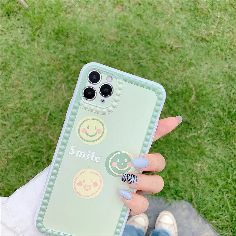 Green TPU iPhone case with geometric pattern and smiley faces in a polka dot frame for multiple models.